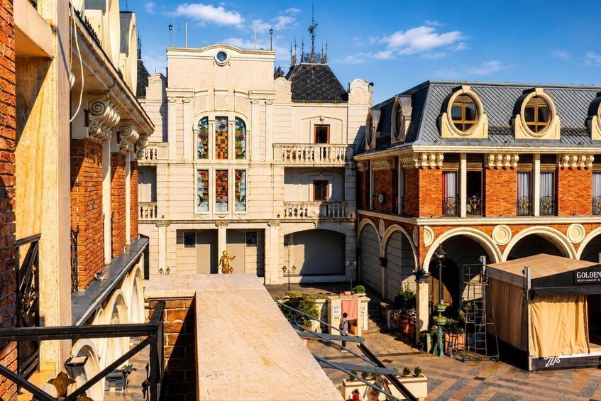 Un bâtiment historique doté de fenêtres en arc de cercle et d’un balcon, d’un espace extérieur couvert aménagé en coin salon et d’une statue dans la cour. 3