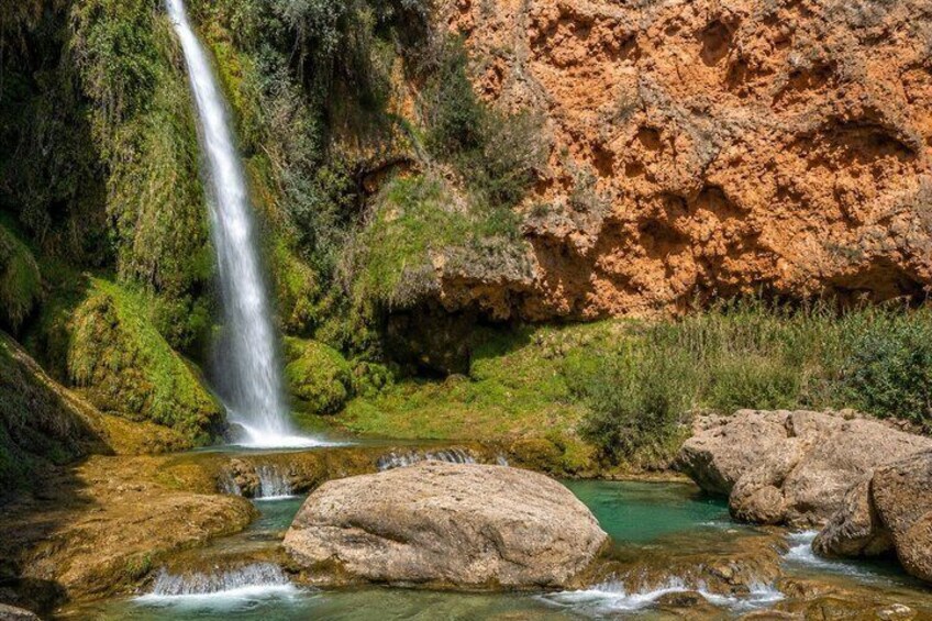 A waterfall, rocky terrain, and a clear stream. 2