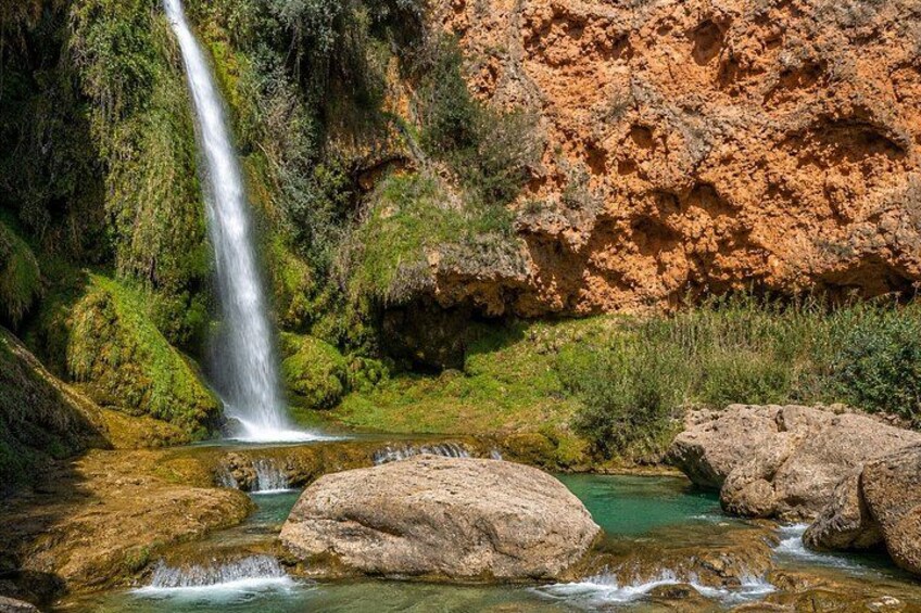 A waterfall, rocky terrain, and a clear stream. 4