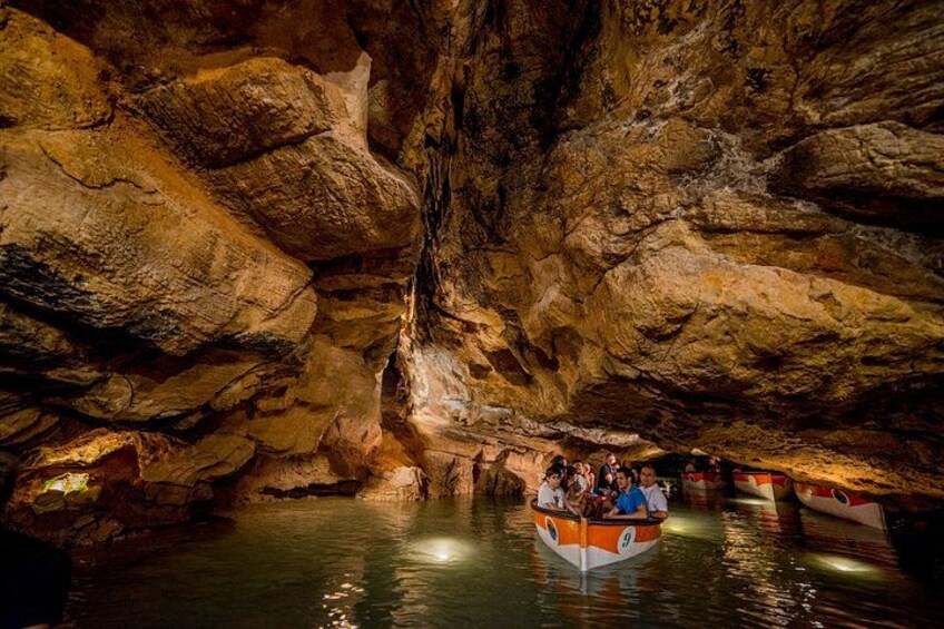 A boat tour through a cave with water and rock formations. 5