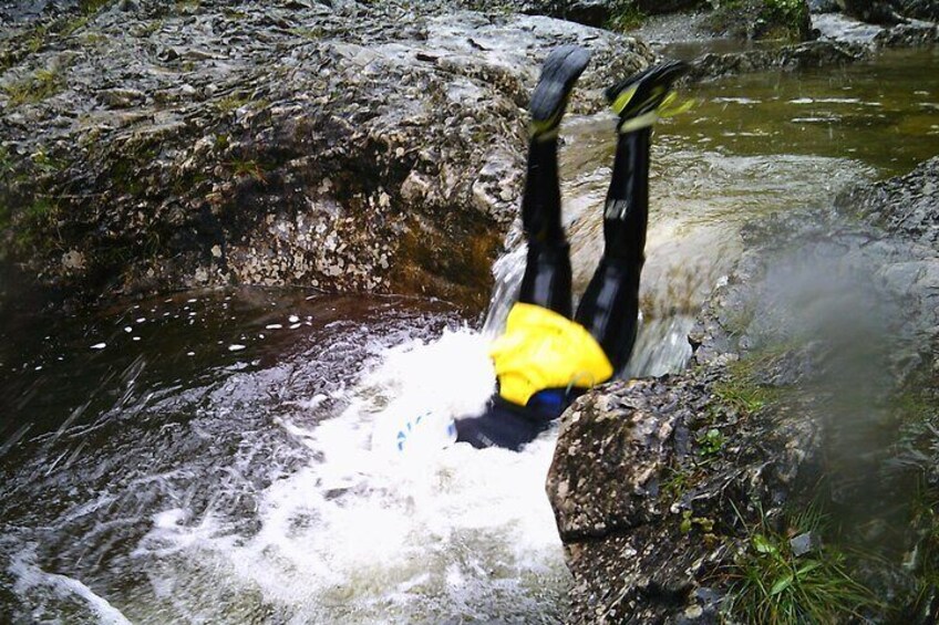 A person performing a backflip in a river. 4