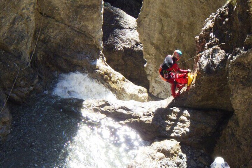A person rappelling down a rocky cliff. 1