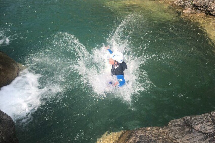 A person kayaking in clear water near rocky terrain. 3