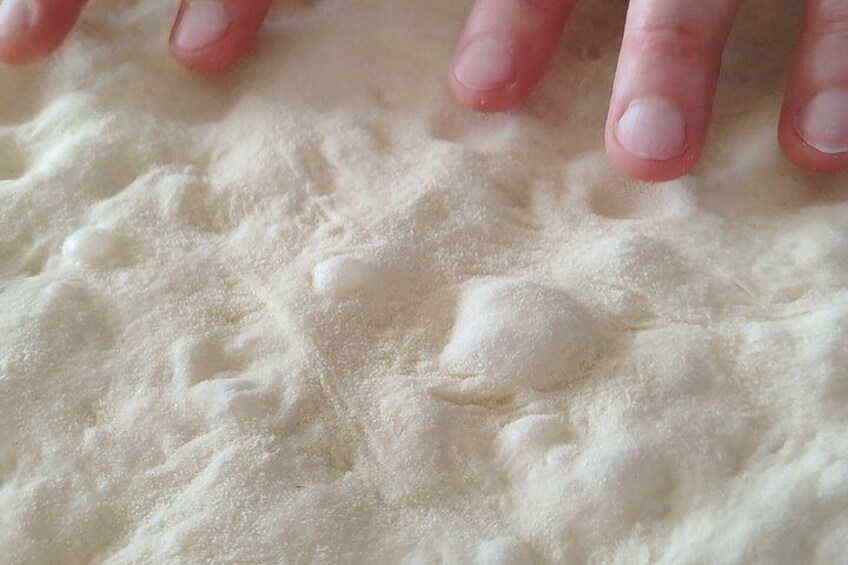 A close-up of a hand pressing into flour. 5
