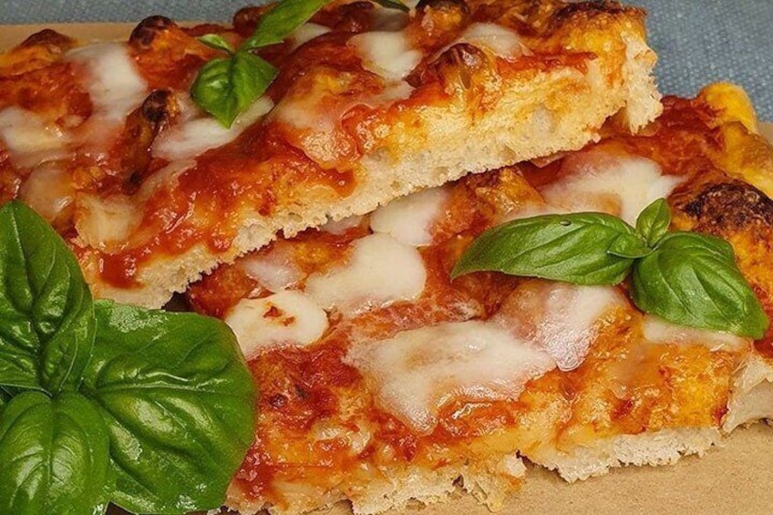 A close-up of a pizza with melted cheese and basil leaves. 5