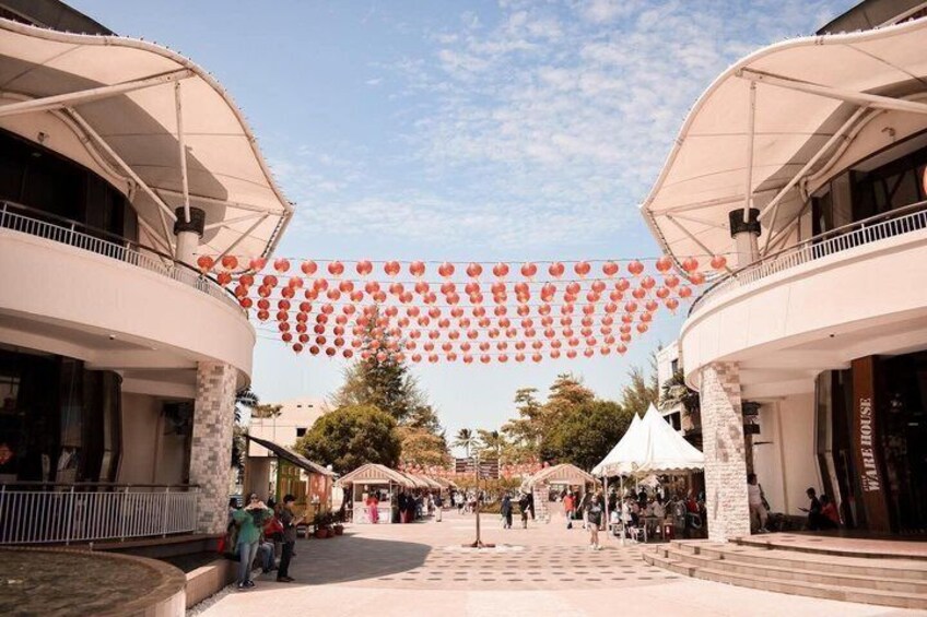 A pedestrian mall with shops, outdoor seating, and red lanterns. 3