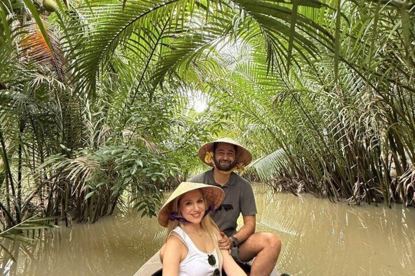 Two people in a boat surrounded by dense tropical vegetation. 4