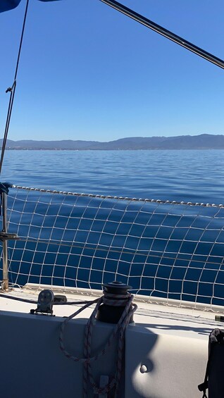 A boat's netting, calm water, and distant mountains. 5