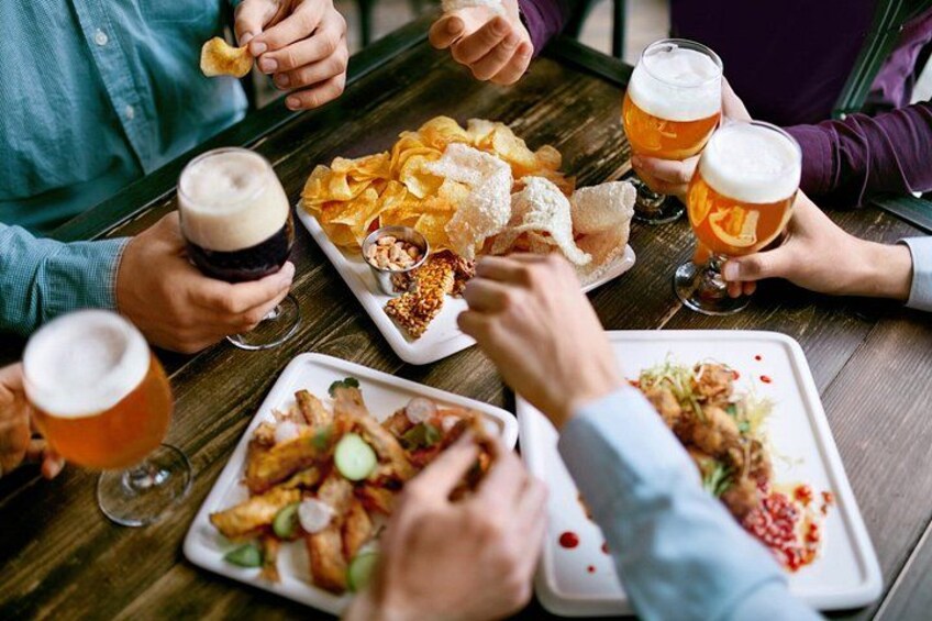 People sitting around a table with food and drinks. 1