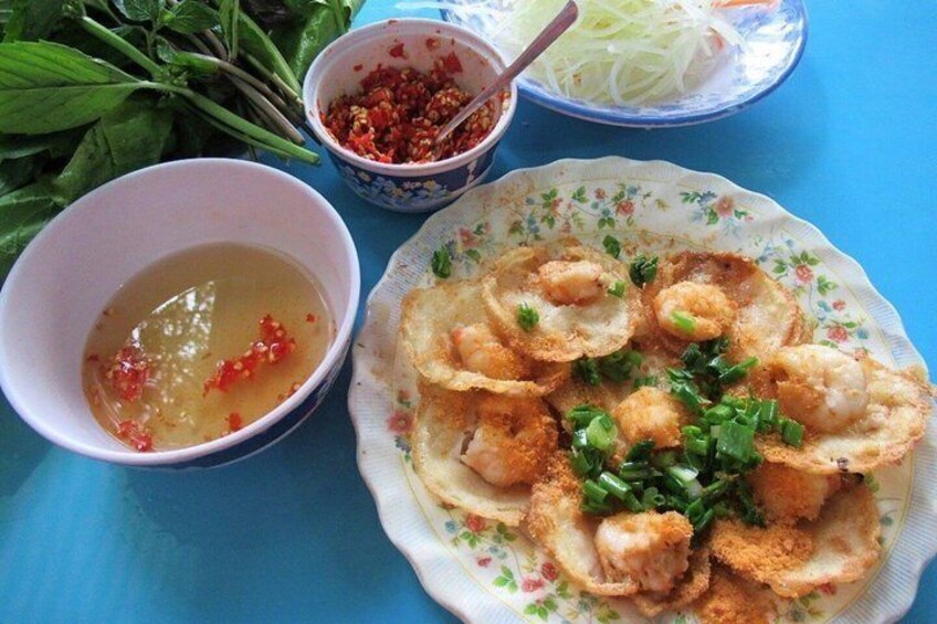 A plate of fried shrimp garnished with green onions, a bowl of dipping sauce, and a bowl of sliced vegetables. 5