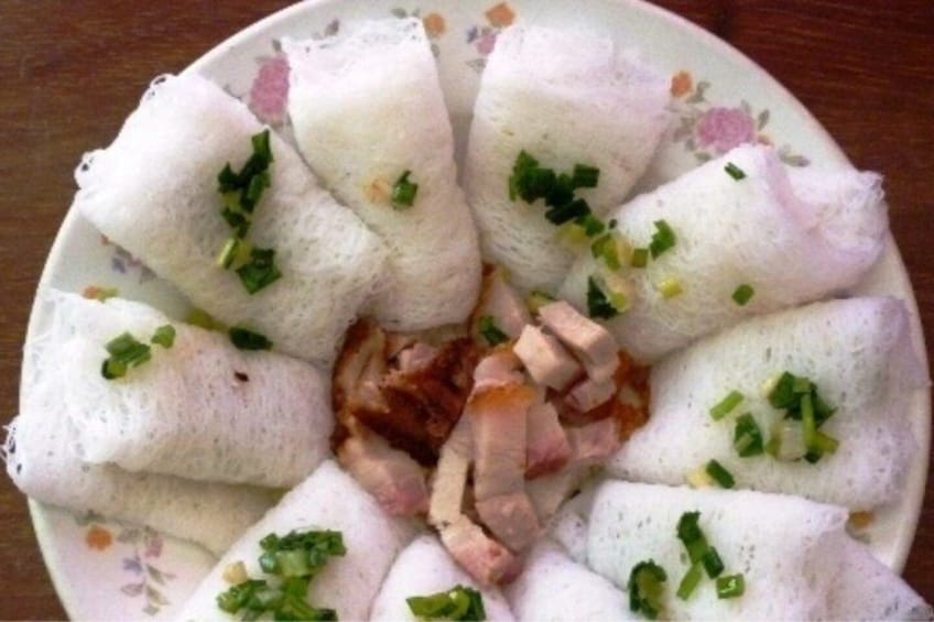A plate of spring rolls with meat and garnished with chopped green onions. 2