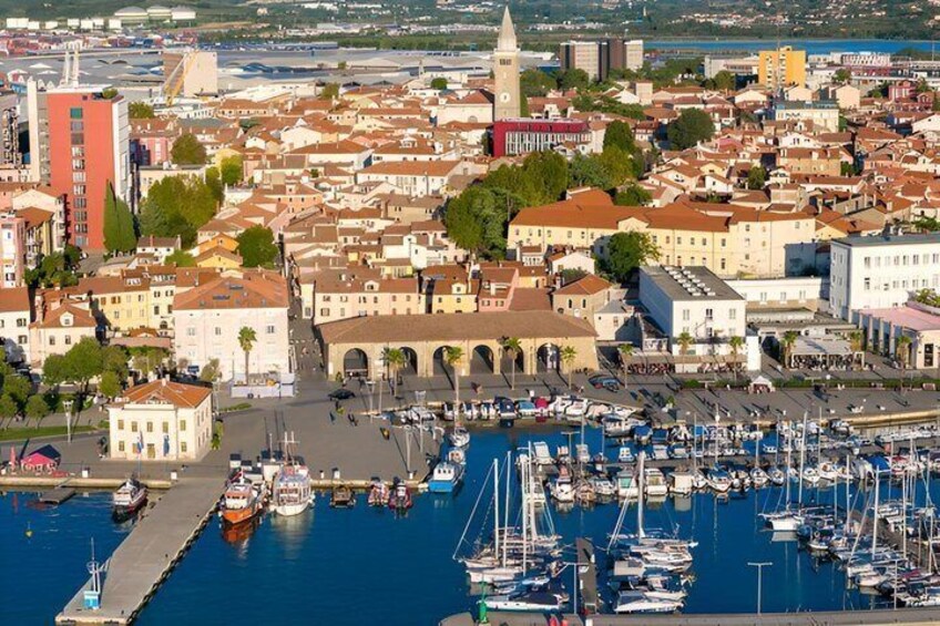 A coastal town with a marina, historic buildings, and a prominent tower. 1