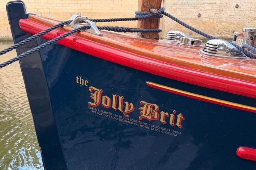 A boat named 'the Jolly Brit' with a red and black hull, tied to a dock. 5