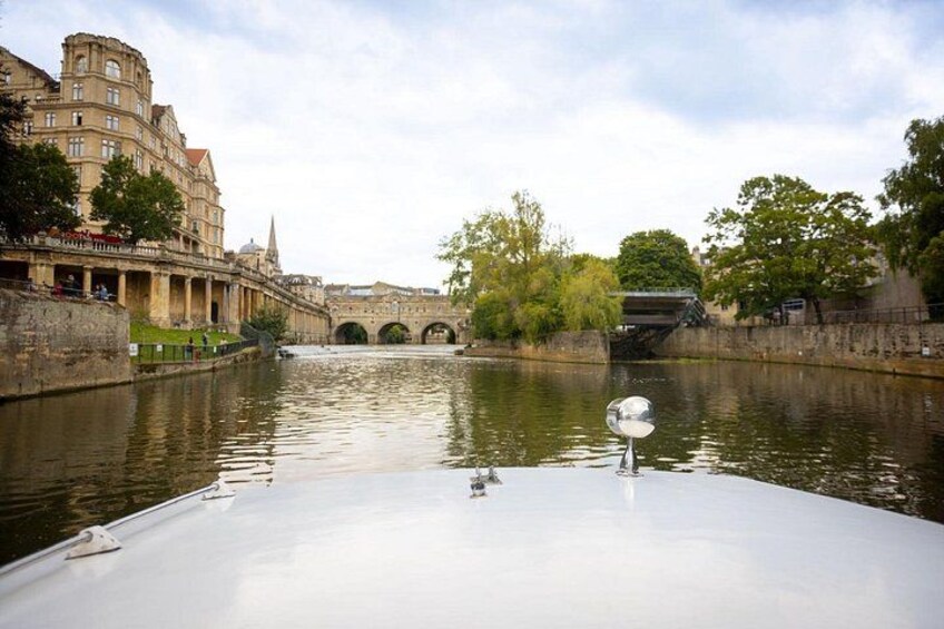 A river with a bridge, buildings, and a boat. 2