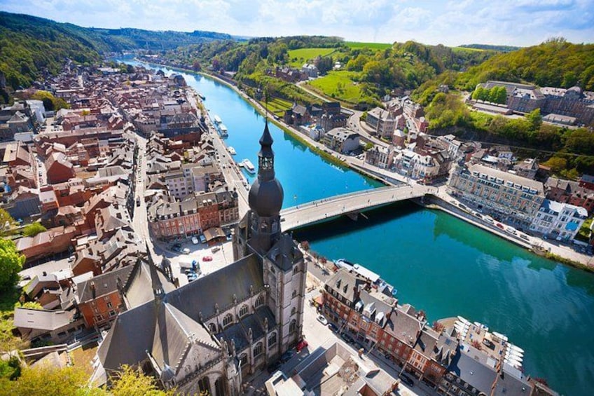A river flowing through a town with historic buildings, a prominent church, and a bridge. 4