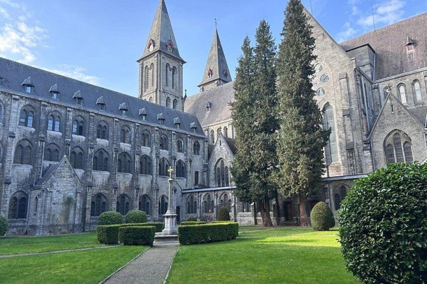 A historic building with a large courtyard, a central fountain, and two prominent towers. 1