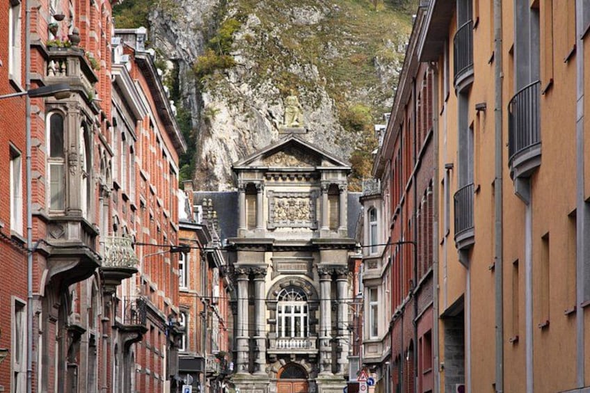 A narrow street flanked by historic buildings with a prominent church at the end. 3