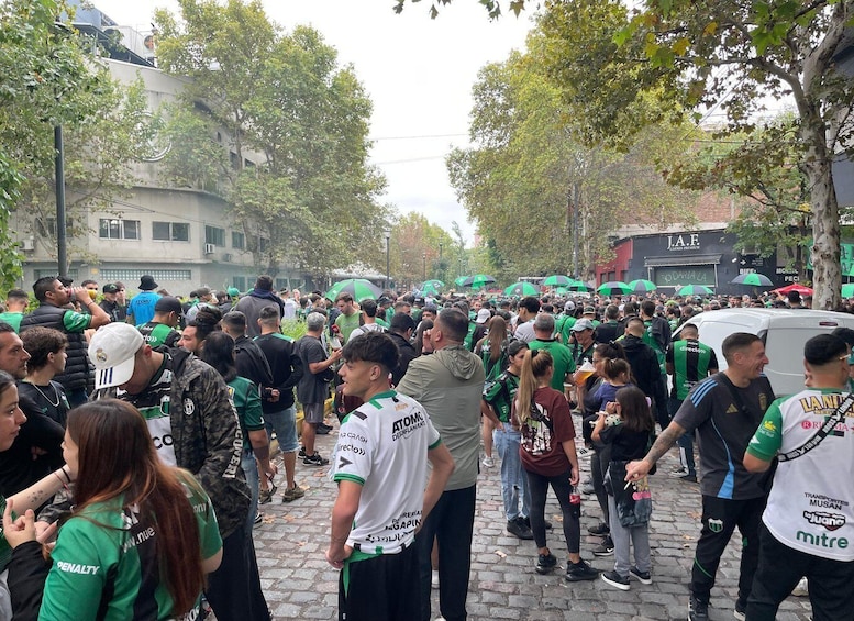 A crowded street with people wearing green and white sports jerseys. 5