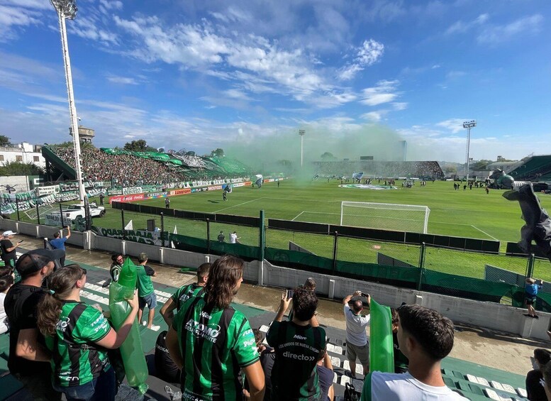 A soccer stadium with a green field, goalposts, and a crowd of spectators. 3