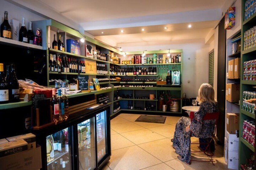A liquor store with shelves of bottles and a customer browsing. 2