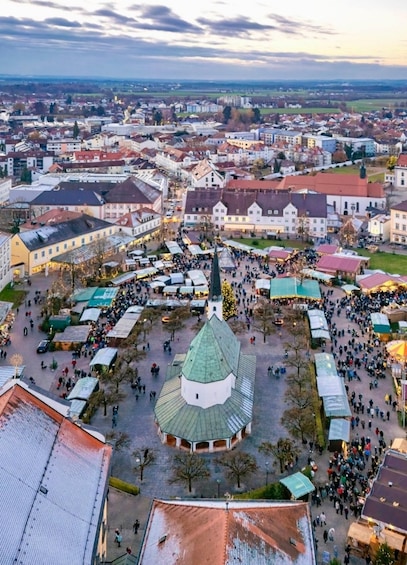 An aerial view of a town square with a central church, surrounded by buildings and market stalls. 3