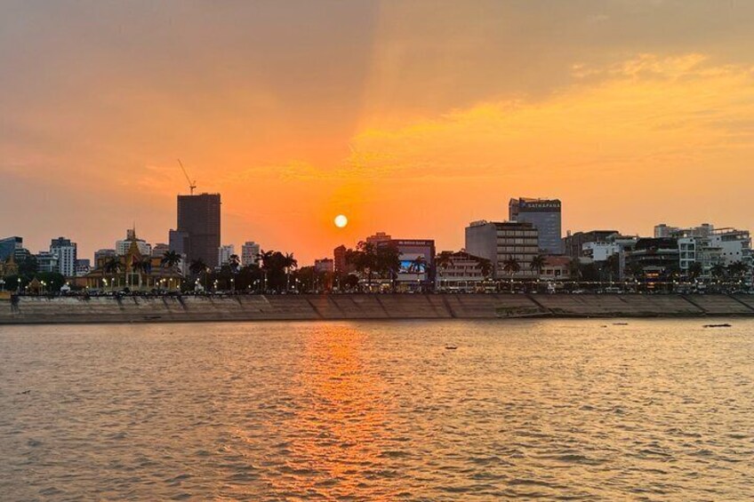 A sunset over a city skyline with buildings and a beach. 4