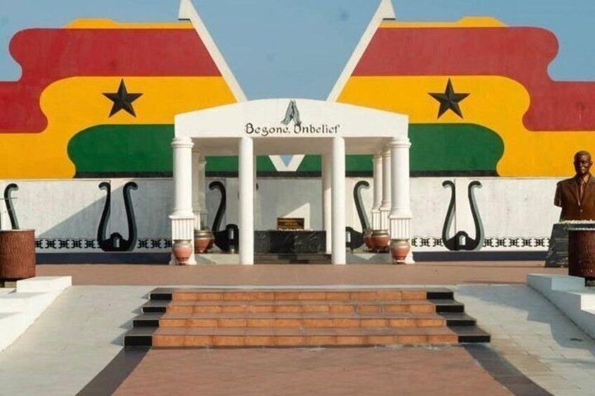 A building facade with a large flag, a statue, and steps leading to the entrance. 3