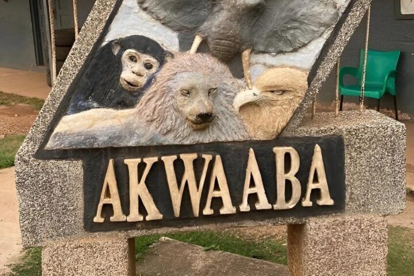 A stone sign with animal carvings and the name 'AKWAABA' in large letters. 4