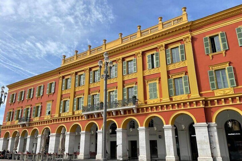A red and yellow building with arched windows and columns. 2