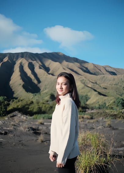 A person standing with a mountain in the background. 1