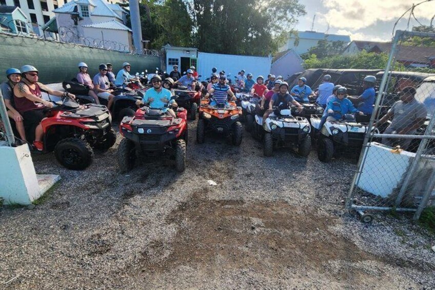 A group of people on ATVs in a parking lot. 1