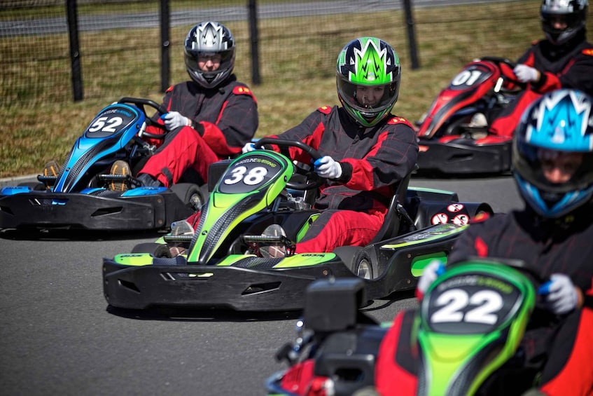 Go-karts with racing numbers 22, 38, and 52 on a track. 2