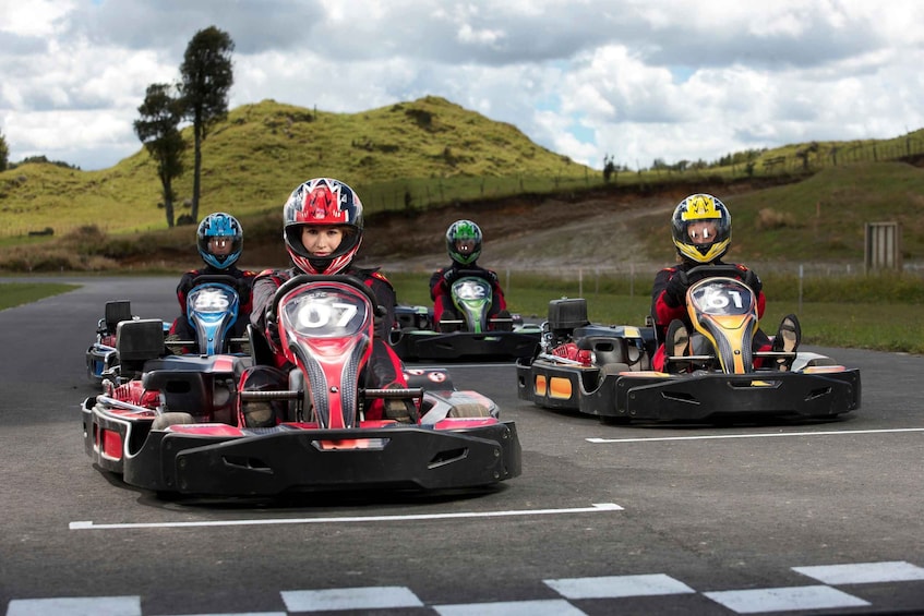 Go-karts on a race track with a hilly landscape in the background. 1