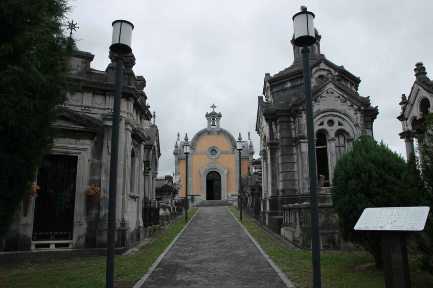 A cemetery with ornate tombs and a central building with a bell tower. 5