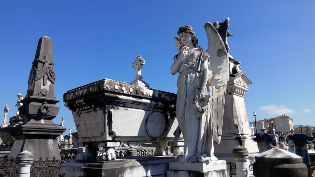 A cemetery with various statues and monuments, including a prominent angel statue. 3