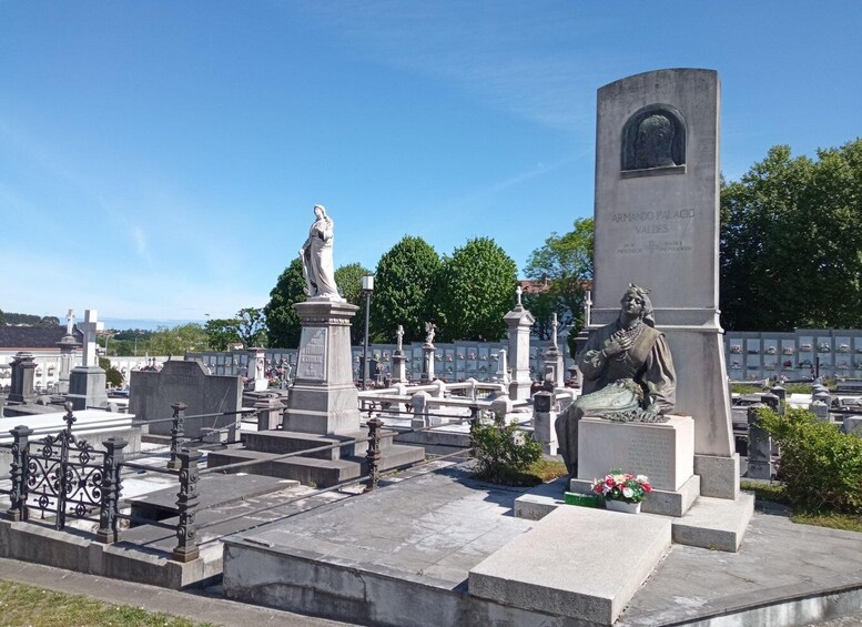 A cemetery with gravestones, statues, and a memorial monument. 2