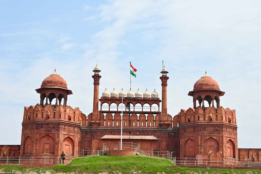 A large, historic building with two domed towers and a central archway. 1