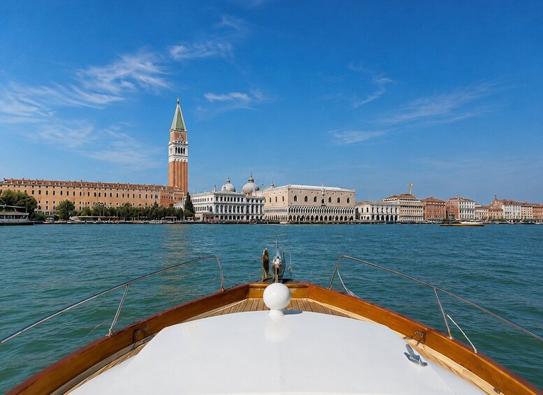 A boat on Venice's Grand Canal with the Doge's Palace and the bell tower of St. Mark's Basilica in the background. 4
