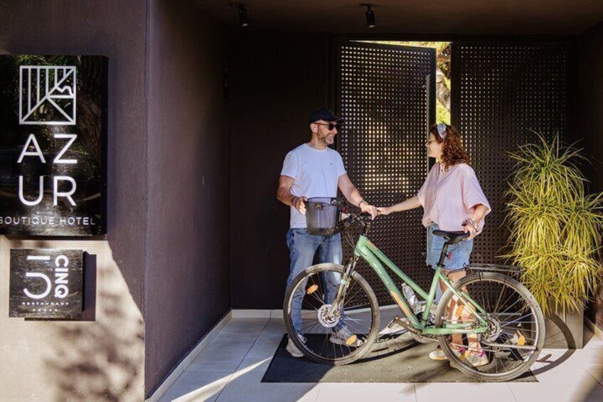 A man and a woman shaking hands in front of a boutique hotel named AZUR. 4