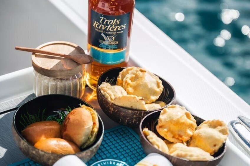 A boat with a bottle of Trois Rivières rum, bowls of food, and a spoon. 2