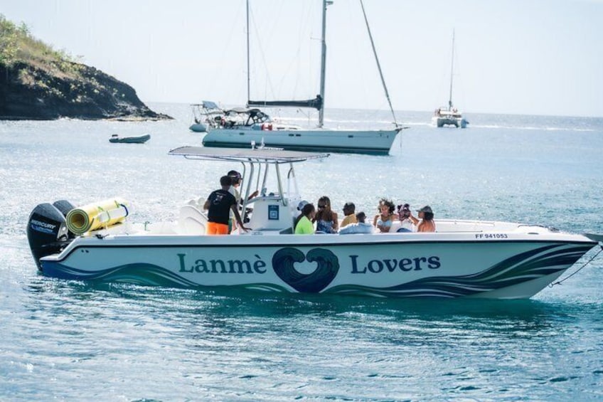 A boat named 'Lanné Lovers' with passengers and a guide on the water. 1
