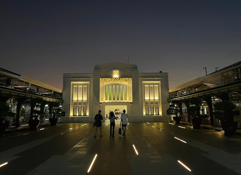 A modern building with illuminated windows and a sign reading 'YOGYAKARTA' at dusk. 1