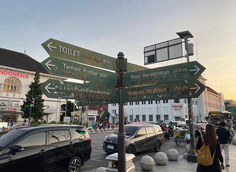 A directional signpost with multiple arrows pointing to various destinations such as 'TOILET,' 'TAMAN PINTAR 350m,' and 'Pasar Beringharjo 260m.' 1