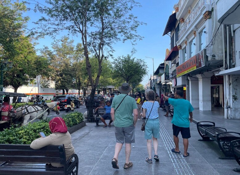 A busy street with pedestrians, a horse-drawn carriage, and shops. 5