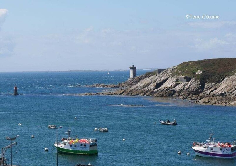 A coastal scene with boats, a lighthouse, and rocky cliffs. 3