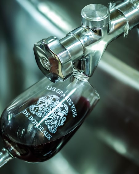 A metallic tap with a glass container engraved with 'LES GRANDS VIN DE BORDEAUX.' 3