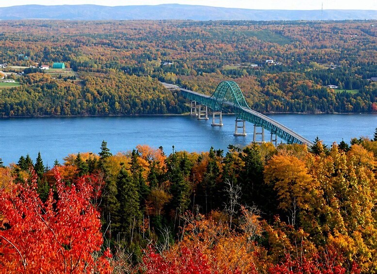 A bridge over a lake surrounded by autumn foliage. 2