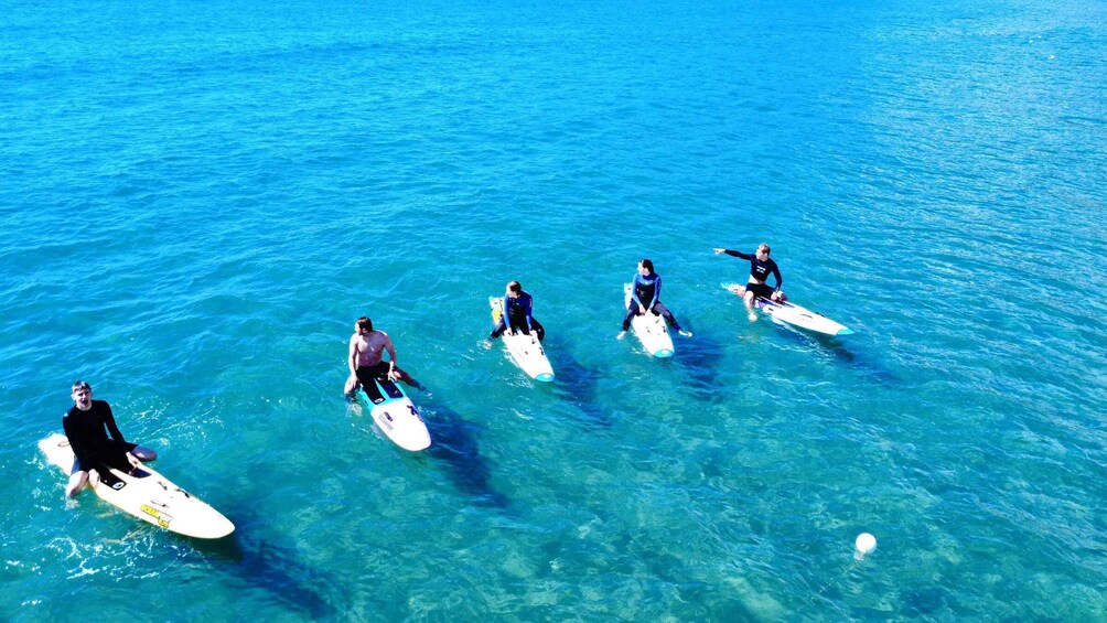 A group of people on surfboards in the ocean. 2