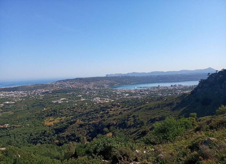 A coastal landscape with a town, a bay, and distant mountains. 5