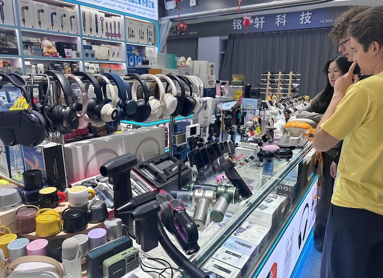 A store with various electronic devices on display, including headphones, cameras, and audio equipment. 3